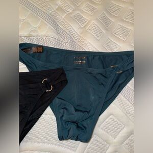 Fenty men swim briefs black and teal with silver chain on side.